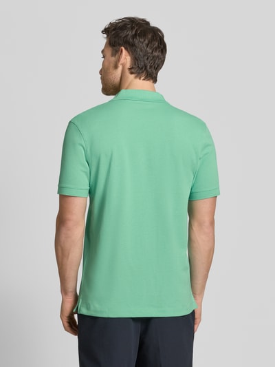 Männermodel trägt Regular Fit Poloshirt aus reiner Baumwolle Modell 'PALLAS' von BOSS, Optik: Unifarben, Ganzkörperansicht Rückansicht.