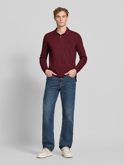 Männermodel trägt Regular Fit poloshirt uit puur katoen van MCNEAL in bordeauxrood, Polokraag met knoopsluiting, labelstitching, shirt met lange mouwen, ruglengte bij maat M: 73 cm, voorkant volledige lichaamsopname.