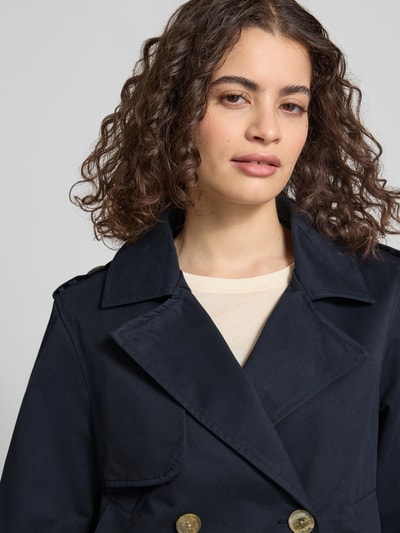 Vrouwenmodel draagt Regular Fit Trenchcoat met Umlegekragen van Review, katoen, marineblauw, dubbele knoopsluiting, steekzakken, close-up bovenlichaam.