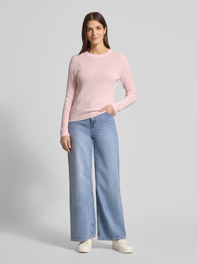 Frauenmodel trägt Strickpullover mit gerippten Abschlüssen Modell 'dalo' von Vila in Rosa, kombiniert mit hellblauer Jeans, Ganzkörperansicht von vorne. Slim Fit aus reiner Baumwolle, Rundhalsausschnitt.