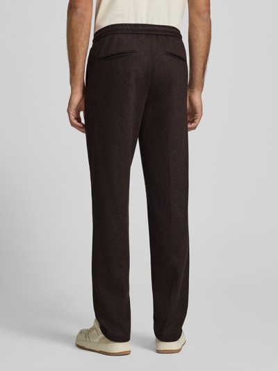 Mężczyzna nosi Hose mit elastischem Bund und Tunnelzug od Profuomo, brązowy materiał z domieszką wełny, krój regular fit, szerokość w rozmiarze 50: 42 cm, długość nogawki wewnętrznej w rozmiarze 50: 85 cm, widok całej sylwetki z tyłu.