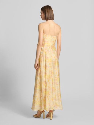 Frauenmodel trägt Maxikleid im Off-Shoulder-Look Modell 'AMINA' von Bardot in Gelb mit floralen Mustern, Lyocell-Mix mit Ramie-Anteil, A-Linie, Rückenlänge bei Größe 36 116 cm, Brustweite bei Größe 36 36 cm, Ganzkörperansicht Rückansicht.