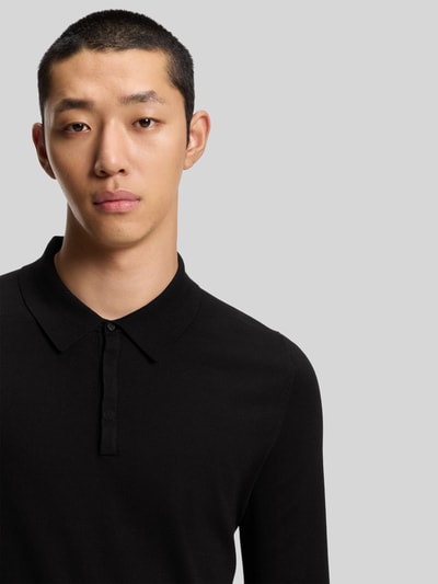 Männermodel trägt Slim Fit Strick-Poloshirt aus Viskose-Mix Modell 'SAN PIPPO-CV' von HUGO, zwart, fijne ribstructuur, Nahaufnahme Oberkörper