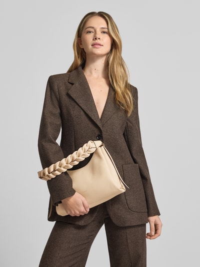 Frauenmodel trägt Handtasche mit Label-Detail Modell 'BOHEME GRANA DOUBLE HOBO' von Coccinelle in Beige, geflochtener Schultergurt, Nahaufnahme Oberkörper.