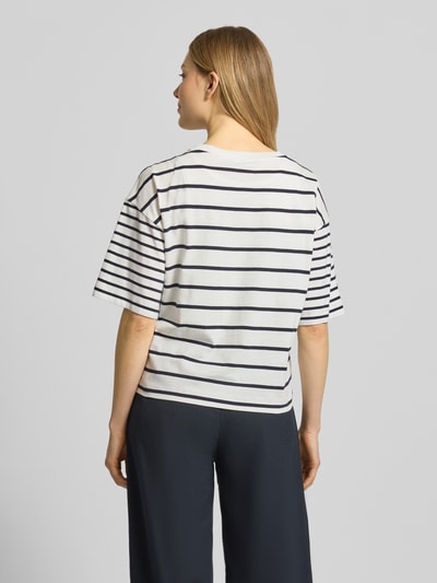 Modelka kobieca nosi Oversized T-Shirt aus reiner Baumwolle od s.Oliver RED LABEL, dwukolorowy wzór w paski, krój oversized, krótki rękaw, bawełniany jersey, widok całej sylwetki od tyłu.