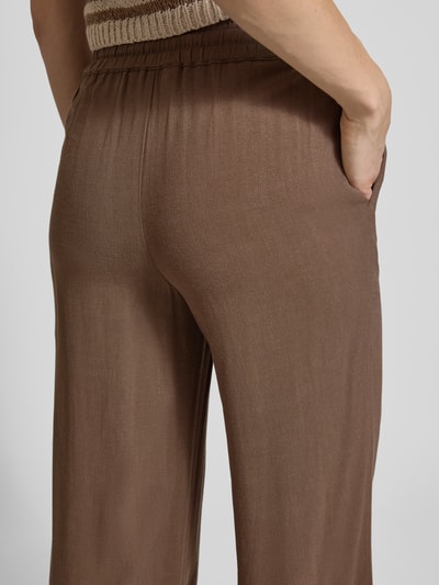 Frauenmodel trägt Regular Fit Weite Hose aus Viskose-Leinen-Mix Modell 'VIVA-GULIA' von Selected Femme, Optik: Unifarben, Flammgarn, seitliche Eingrifftaschen, elastischer Bundabschluss, Nahaufnahme Rückansicht.