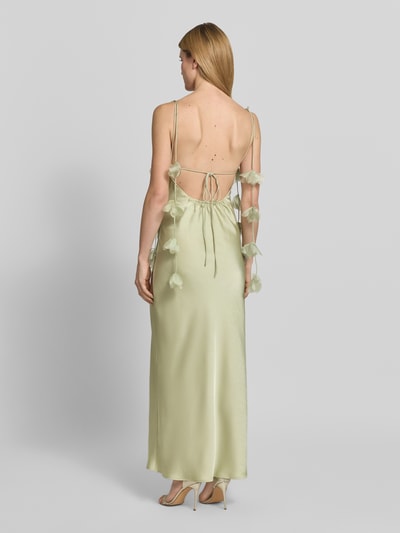 Kobiece model prezentuje długą, jasnobeżową sukienkę satynową Neo Noir, model 'Abendkleid mit floralen Details Modell Colly', z kwiatowymi detalami na ramiączkach, głębokim dekoltem na plecach i sznurowaniem, krój slim fit; zdjęcie całej sylwetki z tyłu.