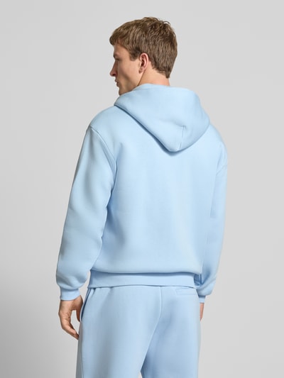 Männermodel trägt Regular Fit Sweatjacke mit Reißverschluss von Review in Hellblau, Baumwoll-Mix, Kapuze, Ganzkörperansicht Rückansicht.