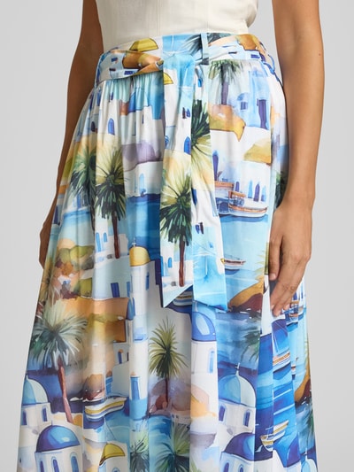 Vrouwenmodel draagt midirok uit viscosemix met all-over motiefprint, sierstrik, A-lijn van More & More, detailopname taille.