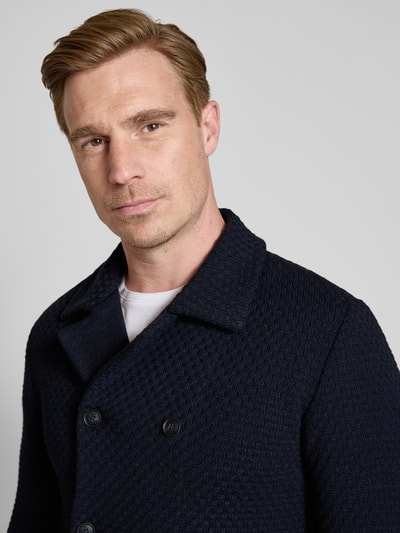Männermodel trägt Slim Fit Cardigan mit Leinen-Alpaka-Anteil in Strick-Optik von Manuel Ritz, dunkelblau, Strukturmuster, Nahaufnahme Oberkörper. Herren Cardigan, Material-Mix, Umlegekragen, doppelte Knopfleiste.