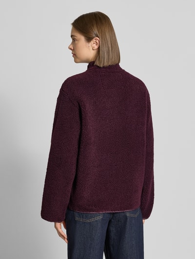 Frauenmodel trägt Teddyjacke mit Stehkragen Modell 'VERA' von JJXX in dunklem Lila, strukturierte Oberfläche, Ganzkörperansicht Rückansicht. Damen Teddyjacke mit gerader Passform, Knopfleiste, Eingrifftaschen, elastische Abschlüsse, Maße für Größe S.