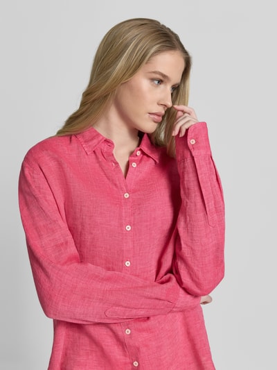 Frauenmodel trägt Hemdbluse aus Leinen mit Kentkragen Modell 'MIRA' von 0039 Italy, leuchtendes Pink, strukturierte Textur, Nahaufnahme Oberkörper. Reines Leinen, Regular Fit, Knopfleiste, Sportmanschetten.
