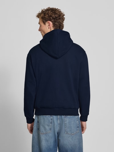 Männermodel trägt Relaxed Fit Hoodie aus katoenmix von Lacoste in dunkelblau, lichte jeans, Ganzkörperansicht Rückansicht, Heren sweatshirt