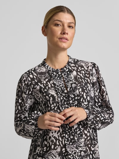 Frauenmodel trägt Regular Fit Langarmbluse mit Allover-Muster Modell 'REMIX SPORTS D' von Marc Cain in Schwarz-Weiß, Nahaufnahme Oberkörper, Damen Langarmbluse von Marc Cain.