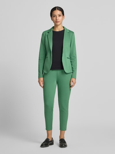 Frauenmodel trägt Blazer mit Viskose-Anteil Modell 'Kate' von ICHI in sattem Grün, taillierte Passform, Reverskragen, Ganzkörperansicht von vorne. Elastischer Material-Mix, Paspeltaschen, Länge bei Größe S: 59 cm, Brustweite: 45 cm, Ärmellänge: 55 cm.