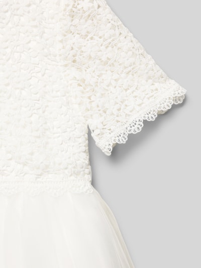 Mädchen trägt Knielanges Kleid mit Rundhalsausschnitt von DANAMADE, taillierter Schnitt, blickdichtes Unterkleid, Detailaufnahme.