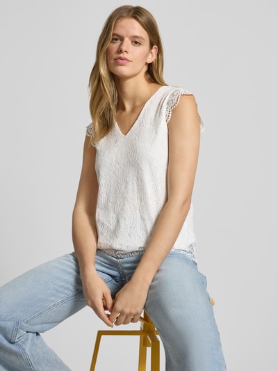 Frauenmodel trägt Slim Fit Blusentop mit Spitzenbesatz Modell 'OLLINE' von Pieces, Optik: Unifarben, Muster: floral, abgerundet, Nahaufnahme Oberkörper.