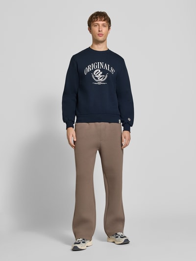 Männermodel trägt Sweatshirt mit Label-Print Modell 'FREDERIKSBERG' von JACK & JONES in Dunkelblau, Regular Fit, Baumwoll-Mix, Ganzkörperansicht von vorne.
