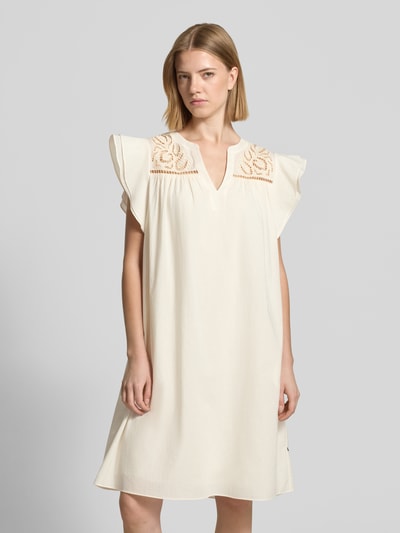 Frauenmodel trägt Relaxed Fit Minikleid mit Loch-Stickerei von ROBE LÉGÈRE aus reiner Baumwolle, hell cremefarben, Tunika-Ausschnitt, Kappärmel, Ganzkörperansicht von vorne.