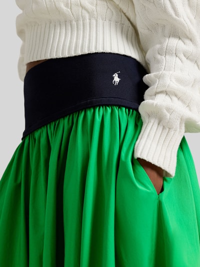 Vrouwenmodel draagt 'Ausgestellter Midi-Rock aus reiner Baumwolle' van Polo Ralph Lauren in two tone groen met logo-stitching, detailopname taille