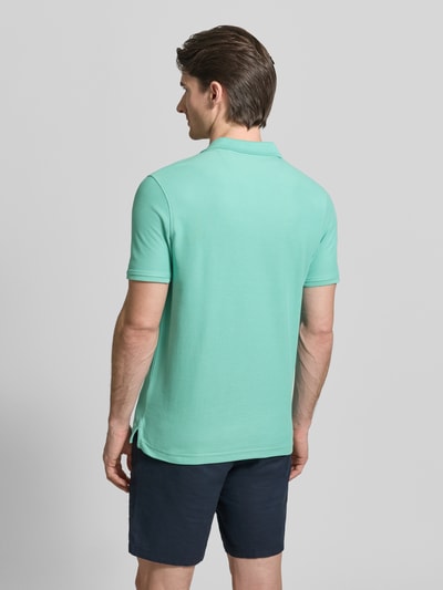 Männermodel trägt Poloshirt mit Logo-Stitching Modell 'PERFORMANCE' von Lerros in Mint, Baumwoll-Mix, Regular-Fit, Rückenlänge 73 cm, Ganzkörperansicht Rückansicht.
