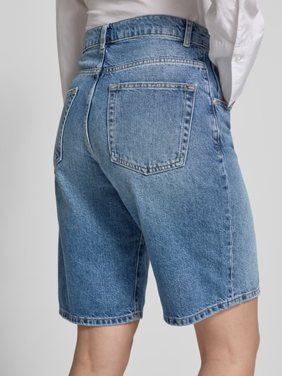Frauenmodel trägt Regular Fit Jeansshorts aus reiner Baumwolle Modell 'MATE' von Only in hellblauer Denim-Twill-Optik, 5-Pocket-Design, Ganzkörperansicht Rückansicht.