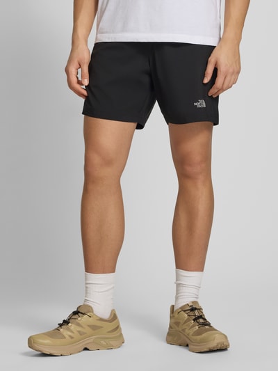 Männermodel trägt schwarze Regular Fit Shorts mit Eingrifftaschen von The North Face, elastischer Bund, Nahaufnahme Oberschenkelansicht.