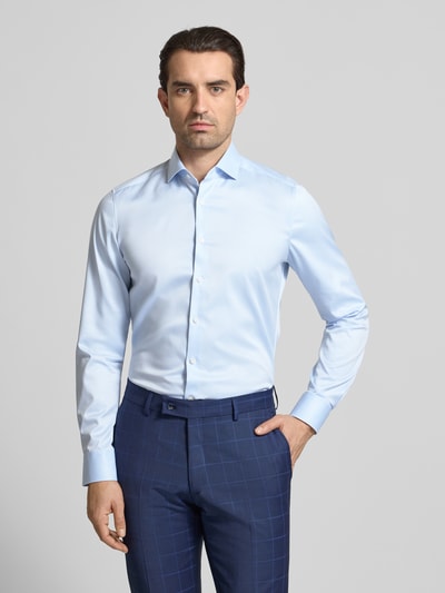 Männermodel trägt Slim Fit Business-Hemd in unifarbenem Design mit Kentkragen von OLYMP Level Five aus reiner Baumwolle, Nahaufnahme Oberkörper.