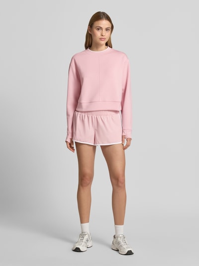 Frauenmodel trägt Cropped Sweatshirt Modell 'tasmin' von VARLEY in Rosa mit Modal-Mix, Stretch-Anteil, Rundhalsausschnitt, Ganzkörperansicht von vorne.