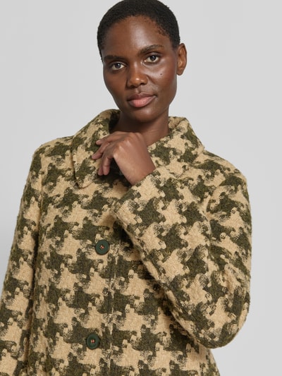 Vrouwenmodel draagt Mantel met Kragen aus Kunstfell van Marc Cain, materiaalmix met wol, regular fit, all-over look, knoopsluiting, opgestikte zakken, detailopname bovenlichaam.