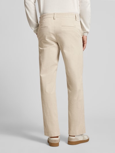 Męski model nosi beżowe chinosy Straight Fit Chino aus Baumwoll-Mix model 'Chino_Keyes_DS' von BOSS Orange, widok całej sylwetki z tyłu.