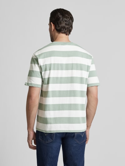 Männermodel trägt Oversized T-Shirt mit Rundhalsausschnitt von Lindbergh, Streifenmuster, Reine Baumwolle, Rückenlänge 67 cm, Ganzkörperansicht Rückansicht.
