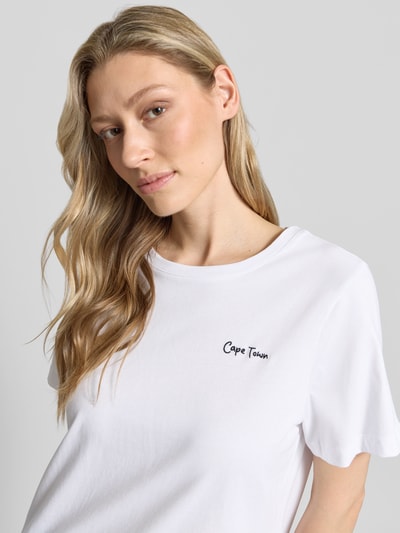 Kobiece modelka nosi T-Shirt mit Statement-Print und Rundhalsausschnitt von Smith and Soul, biała bawełna, krój regular fit, krótki rękaw, nadruk z przodu, długość tyłu w rozmiarze S: 59 cm, zbliżenie na górną część tułowia z przodu.