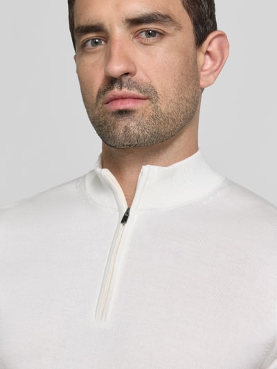 Męski model nosi Strickshirt aus Viskose-Mix mit Stehkragen Modell 'Vadin' von JOOP! COLLECTION, dopasowany krój, mieszanka wiskozy, prążkowana stójka, krótki zamek błyskawiczny, długość tyłu 68 cm, długość rękawów 24 cm, biała gładka faktura, zbliżenie na górną część ciała, przód
