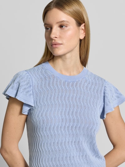 Vrouwenmodel draagt gebreid shirt met volants model 'Ganna' van MOS MOSH, puur katoen, nauwsluitende pasvorm, ronde hals, nahaufnahme bovenlichaam.