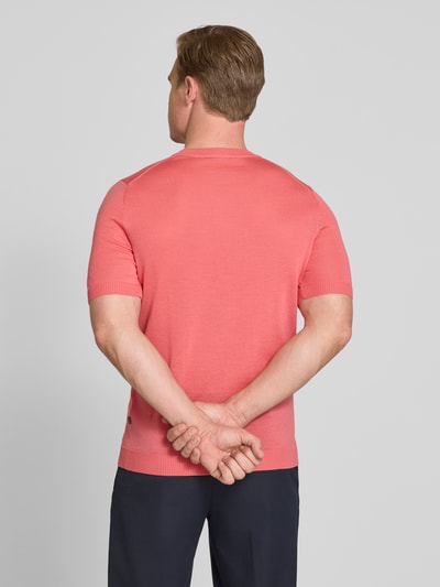 Mannenmodel draagt Strickshirt mit Rundhalsausschnitt van MAERZ Muenchen in slim fit, koraalroze, ribgebreide boorden, labeldetail, ruglengte 66 cm, volledige lichaamsaanzicht achteraan.