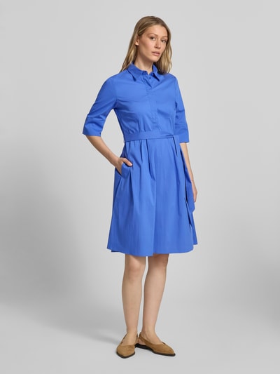 Modelka nosi Knielanges Hemdblusenkleid mit Bindegürtel von Christian Berg Woman Selection, niebieski, bawełna ze stretchem, A-linia, długość do kolan, ukryta listwa guzikowa, pasek, długość tyłu w rozmiarze 36: 99 cm, szerokość w rozmiarze 36: 48 cm, długość rękawa w rozmiarze 36: 37 cm, widok całej sylwetki z przodu.