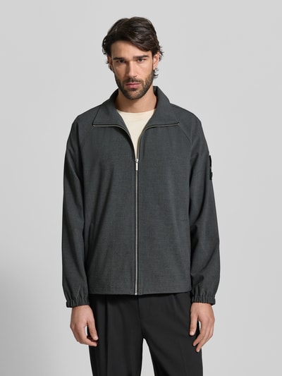 Männermodel trägt Regular Fit Blouson mit Raglanärmeln von s.Oliver BLACK LABEL in Melange-Optik, Reißverschluss, Ganzkörperansicht von vorne.