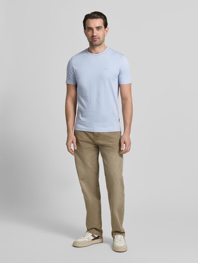 Männermodel trägt Regular Fit T-Shirt aus reiner Baumwolle Modell 'THOMPSON' von BOSS in Hellblau, unifarben, mit Label Print, Rundhals, Ganzkörperansicht von vorne.