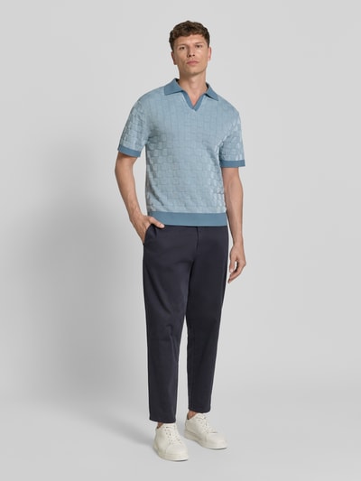 Męski model nosi Relaxed Fit Poloshirt aus reiner Baumwolle Modell 'MILAS' od SELECTED HOMME w wielokolorową kratę, dzianina, krótki rękaw, kołnierzyk polo, V-dekolt, widok całej sylwetki z przodu.