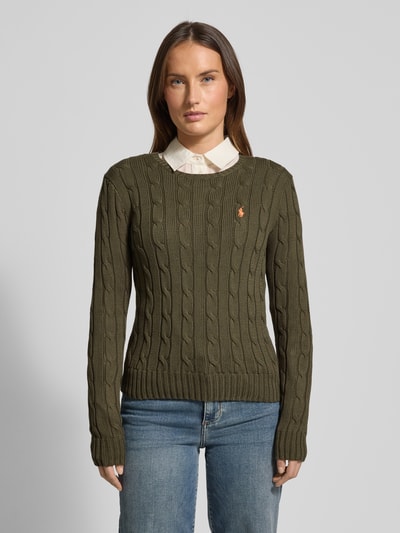 Frauenmodel trägt Strickpullover mit Zopfmuster Modell 'JULIANNA' von Polo Ralph Lauren aus reiner Baumwolle im Slim-Fit mit Rundhalsausschnitt, olivgrün mit Label-Stitching, Rückenlänge 58 cm, Ärmellänge 69 cm, Ganzkörperansicht von vorne.