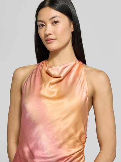 Frauenmodel trägt Abendkleid mit Neckholder Modell 'Andie' von Forever New in glänzendem Satin, ärmel- und schulterlos, Wasserfall-Ausschnitt, körpernahe Passform, Farbverlauf in Orange und Rosa, Nahaufnahme Oberkörper.