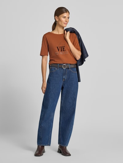 Vrouwenmodel draagt T-shirt met strass-steentjes van MORE, katoenmix met stretch, getailleerde pasvorm, ronde hals, ruglengte maat 36: 57 cm, ganzekörperaanzicht van voren