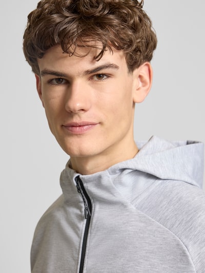 Mannelijk model draagt Regular Fit Sweatjacke mit Kapuze Modell 'Base' van Jack & Jones in lichtgrijs, elastische katoenmix, rits, zakken, detailopname bovenlichaam