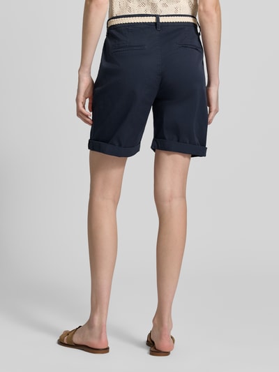 Frauenmodel trägt Chino-Shorts mit Gürtel von MAC aus dunkelblauem Baumwoll-Elasthan-Mix mit Eingrifftaschen, Regular-Fit, Ganzkörperansicht Rückansicht.