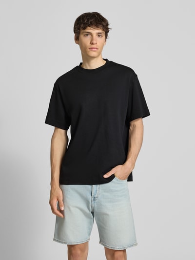 Männermodel trägt T-Shirt mit Rundhalsausschnitt Modell 'EURBAN EDGE' von Jack & Jones in Schwarz, Baumwolle, Modern Fit, Ganzkörperansicht von vorne