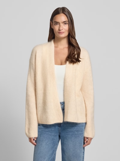 Modelka nosi Relaxed Fit Cardigan aus Kaschmir-Mix von HERZENS, kremowy, struktura dzianinowa, mankiety obszyte, widok całej sylwetki z przodu, długość tyłu w rozmiarze 36: 61 cm, długość rękawa w rozmiarze 36: 54 cm