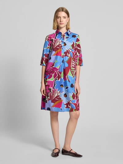 Frauenmodel trägt Relaxed Fit Midikleid mit floralem Allover-Print von Christian Berg Woman Selection aus reiner Baumwolle in bunten Farben, Umlegekragen, Halbarm, Knopfleiste, Ganzkörperansicht von vorne.