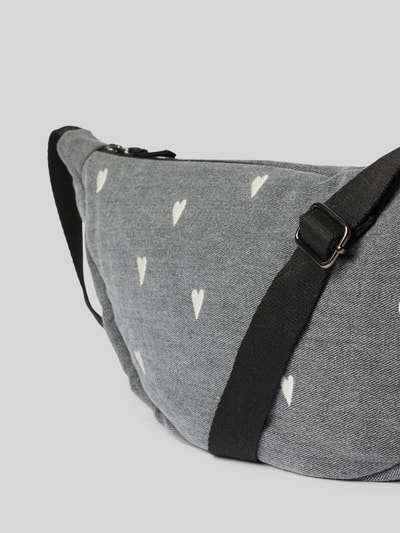 Produktfoto, Fanny Pack aus reiner Baumwolle in Denim-Optik von Studio Noos mit Allover-Motiv-Stitching und Logo-Detail, grauer Grundton, schwarze Riemen, grobe Stoffstruktur, sichtbarer Reißverschluss, verstellbarer Schulterriemen.