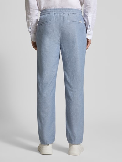 Männermodel trägt Jogpants aus Baumwoll-Leinen-Mix Modell 'WARREN' von Scotch & Soda in Hellblau, Regular-Fit, Ganzkörperansicht Rückansicht.